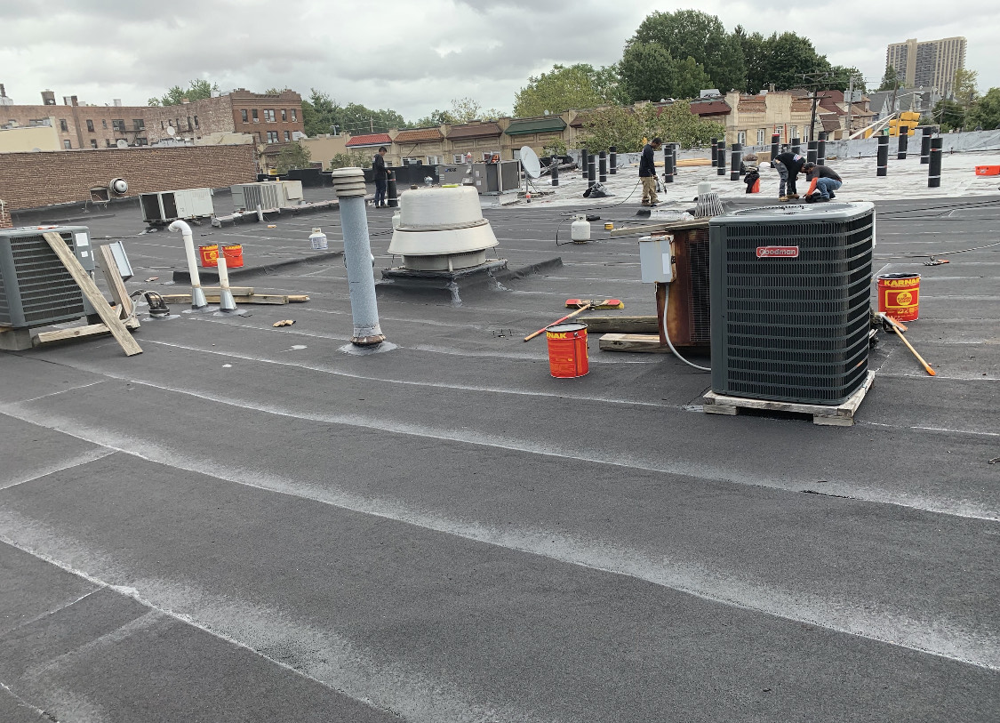 Commercial flat roofing project in progress, with skilled professionals working diligently