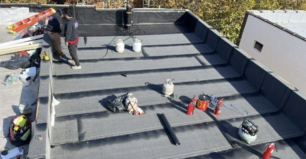 Newly installed torch-down flat roof in Union City, NJ with Manhattan skyline view — Gaby Roofing