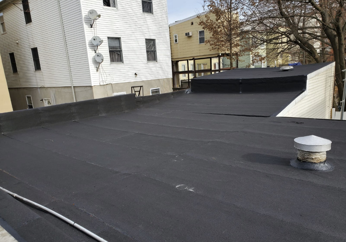 Active flat roof installation in Union City, featuring skilled workers