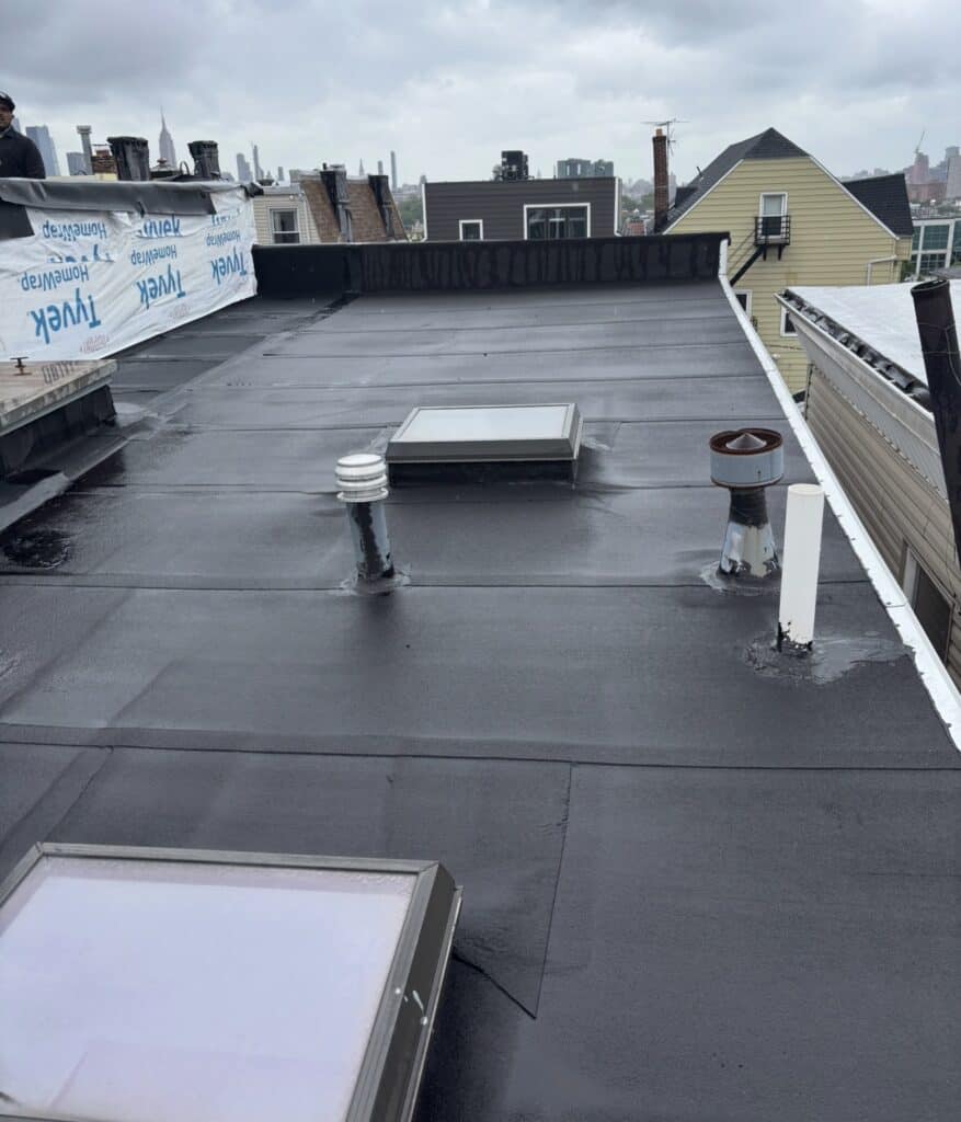 Gaby Roofing crew tearing off shingle and flat roof sections on a Bayonne, NJ residential project