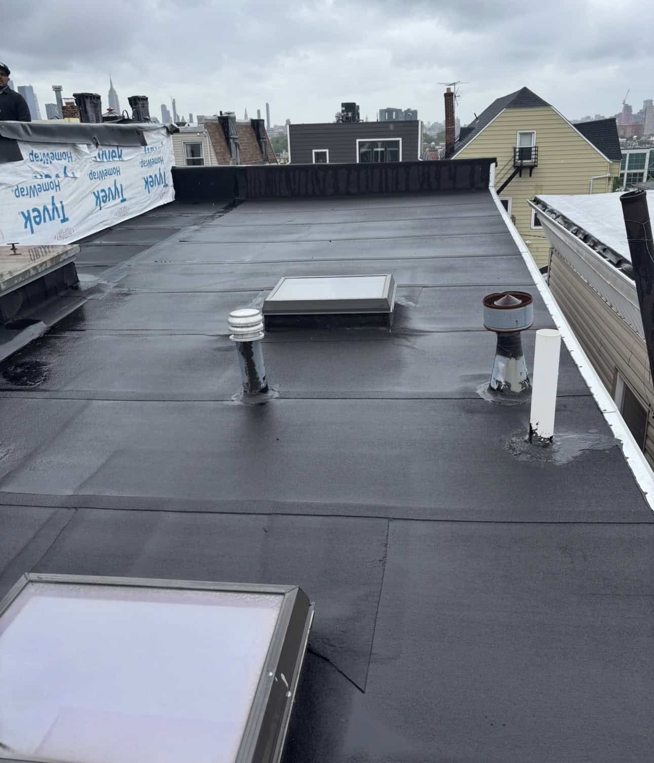 Gaby Roofing crew tearing off shingle and flat roof sections on a Bayonne NJ project