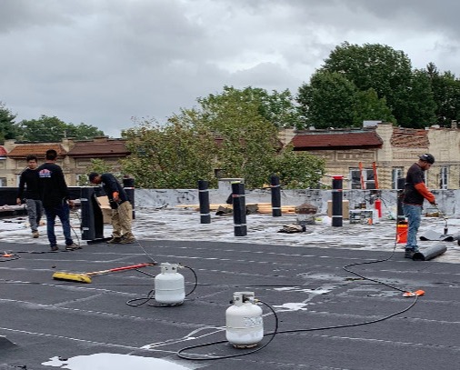 Our dedicated roofing professionals working on a commercial roof in Hudson County