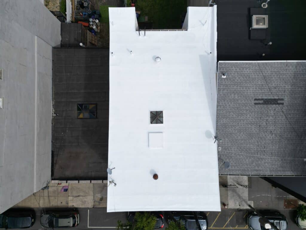 Aerial view of completed silicone roof coating restoration on a Hoboken NJ flat roof — Tri-Built 985 silicone system installed by Gaby Roofing Flat Roof Specialist over a modified bitumen base.