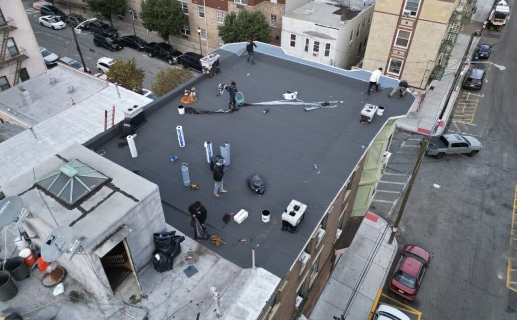 Gaby Roofing crew installing torch-down flat roof with propane torches in North Bergen, NJ