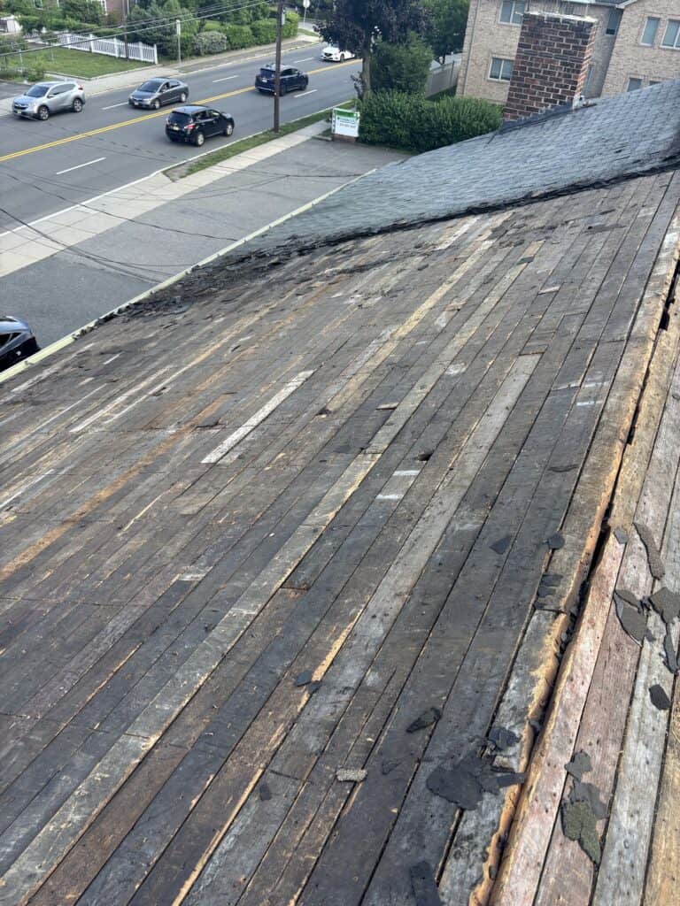 Original wood plank roof decking exposed during shingle tear-off in Bergen County, NJ