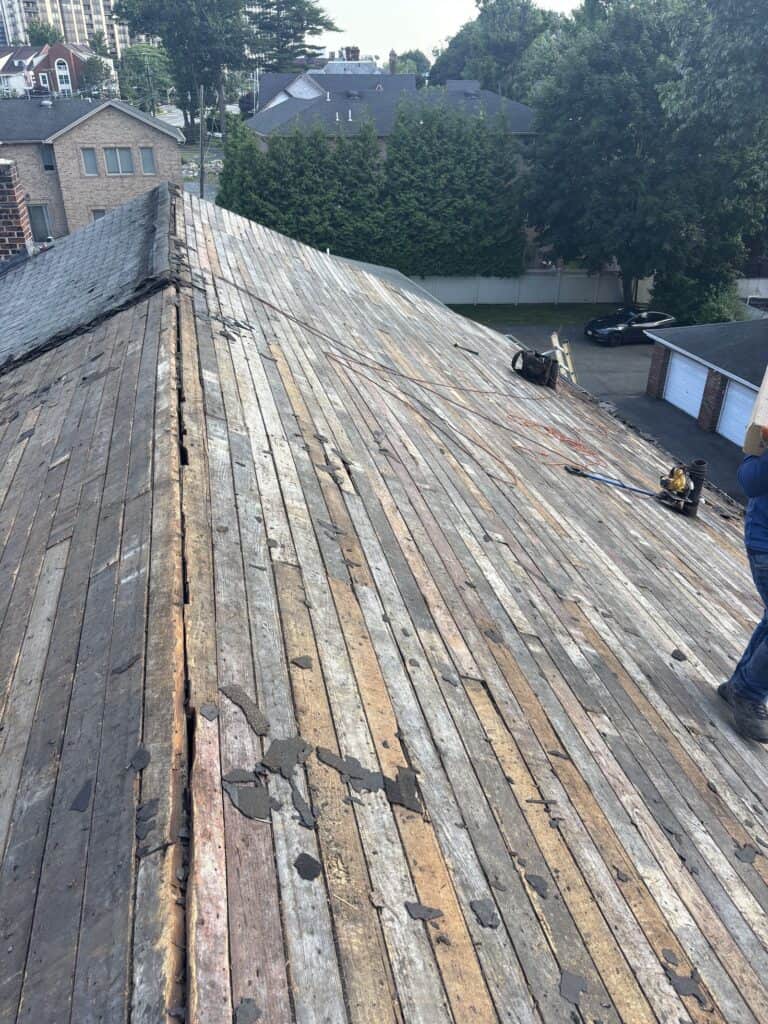Tear-off in progress on a pitched shingle roof in Bergen County, NJ