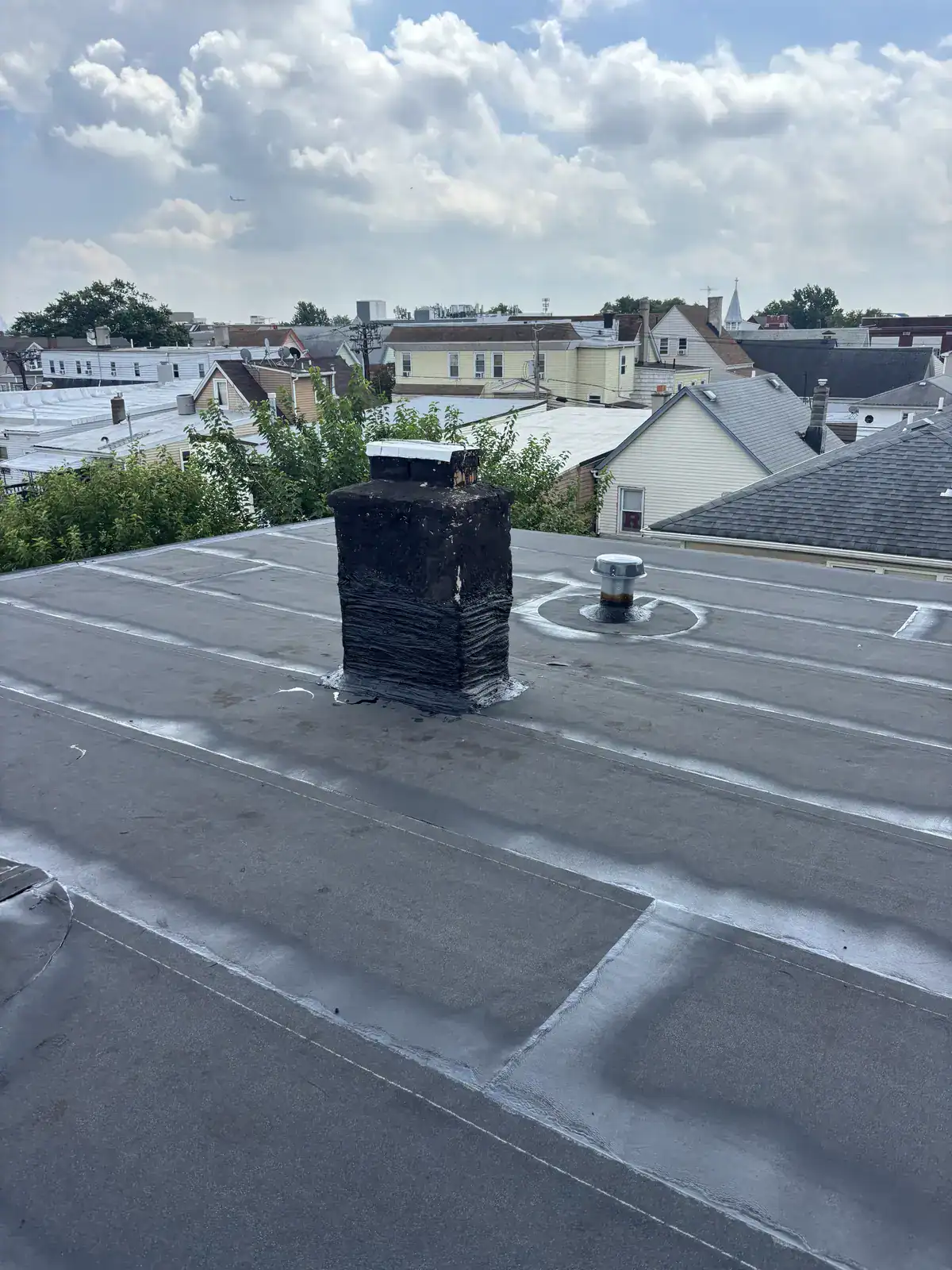 New torch down flat roof with sealed chimney flashing and roof vent in Harrison NJ