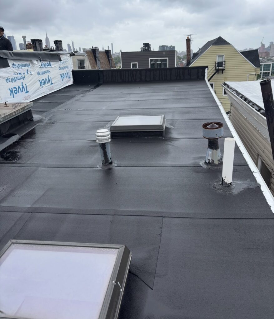 Gaby Roofing crew tearing off shingle and flat roof sections on a Bayonne, NJ residential project