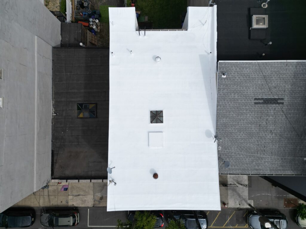 Aerial view of completed silicone roof coating restoration on a Hoboken NJ flat roof — Tri-Built 985 silicone system installed by Gaby Roofing Flat Roof Specialist over a modified bitumen base.